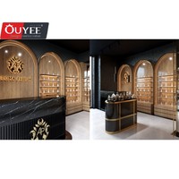 Comptoir présentoir de parfums en marbre au design d'intérieur Parfumerie unique Vitrine murale arquée en placage de bois pour parfumerie avec lumière LED