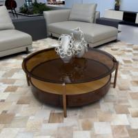 Table basse ronde moderne à deux niveaux avec surface en verre ambré, pieds en métal cuivré et base en bois à motif étoilé