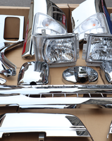 Kit de pièces de carrosserie chromées pour camion Isuzu NPR, comprenant les caches de phares, les garnitures de roue, la calandre et les coques de rétroviseurs.