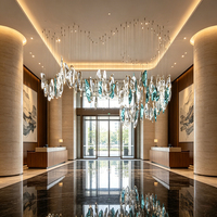 Lustre en verre à feuilles dentelées uniques, style art contemporain, avec pendentifs en cristal cyan et transparent, idéal pour l'éclairage des halls d'hôtel et des escaliers