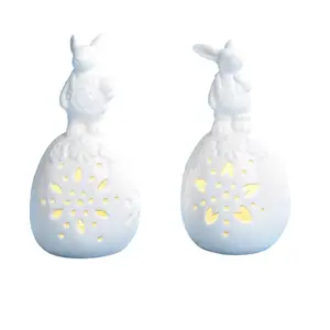 Decoración de Pascua figuritas de conejo de cerámica blanca sentados en huevos conejos de porcelana