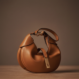 <b>Tan</b> <b>Handbag</b>. Trendy crescent shape with a soft, rounded design. Available at wholesale prices - Product Image 1