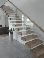 Escalier flottant de luxe avec poutre centrale en acier et garde-corps entièrement en verre pour duplex