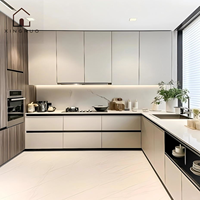 Lemari Dapur Modern Bentuk L XINGRUO dengan Pintu Slab Warna Krem, Unit Tinggi Motif Kayu, dan Meja Dapur Berpenampilan Batu