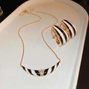 Venta al por mayor blanco y negro gargantilla moda mujer goteo aceite patrón Rhinestone en forma de V collar pendientes conjunto - Product Image 1