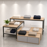 Ensemble de table de présentation à niveaux en MDF et acier inoxydable avec pieds fins noirs et armoire grise sur mesure