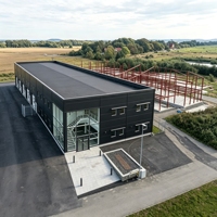 Atelier préfabriqué en structure métallique avec bureau, composants et plans de chantier