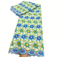 Tissu en dentelle de coton brodé floral coloré avec des strass minuscules brillants incrustés aux centres des fleurs et un artisanat ajouré
