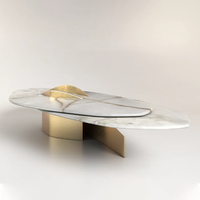 Table basse en marbre courbé avec détails dorés abstraits, style moderne et luxueux, pour salon ou comme table d'appoint.