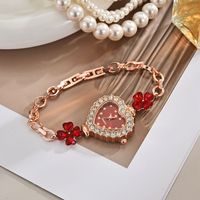 Montre pour femme élégante et chic de style luxe léger, avec chaîne à motif trèfle à quatre feuilles et quartz en forme de cœur