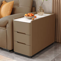 Une petite table de chevet intelligente avec une sensation de double couche, dotée d'un placard latéral de luxe léger, d'une plaque en pierre, d'un sol en cuir et de roulettes