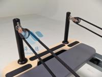Reformer de Pilates commercial en aluminium avec cadre métallique gris mat, pour usage en studio, avec ressorts de qualité