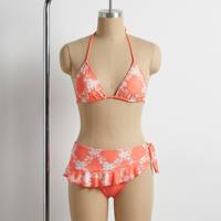 Maillot de bain recyclé personnalisé à pois et motifs floraux, avec bas de bikini froncé taille basse à nouer sur les côtés et mini-jupe de bain intégrée