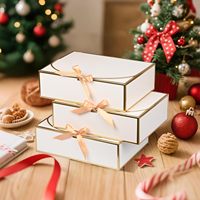 Élégante boîte cadeau pliable en kraft blanc avec dorure à chaud et nœud en ruban beige, idéale pour l'emballage de cadeaux de mariage et d'anniversaire