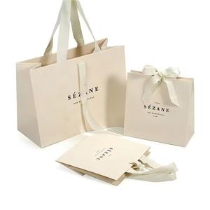 Ensemble de sacs <span class=keywords><strong>en</strong></span> <span class=keywords><strong>papier</strong></span> beige de luxe (3 pièces) avec nœud |   Logo de marque imprimé sur mesure pour l'emballage de produits et de cadeaux - Product Image 1