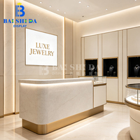Vitrine de présentation de bijoux personnalisée en verre trempé avec panneaux cannelés blancs, en acier doré champagne, circulaire, creuse, avec LED et verrouillable