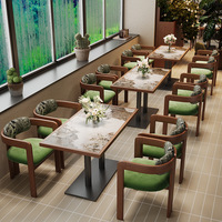 Ensemble de banquettes de restaurant modernes courbes avec dossier en rotin et banc rembourré, et table ronde en pierre frittée pour café et bistro