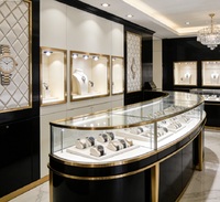 Ensemble de comptoirs de présentation de montres de luxe, vitrine en verre incurvé sur mesure avec éclairage LED et finition dorée pour les magasins de montres haut de gamme et les centres commerciaux