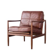 Fauteuil d'appoint en cuir et noyer de style Mid-Century, avec coussin marron à points de couture et rembourrage haute résilience, idéal pour salon ou coin lecture.