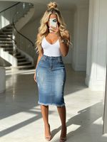 تنورة جينز نسائية متوسطة الطول بخصر مرتفع وحواف مهترئة، تصميم ضيق بلون فاتح، مناسبة للصيف