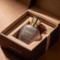 Flacon de parfum vide en ambre champagne à facettes multiples, avec capuchon doré en forme de couronne, dessus en dôme noir, logo personnalisé et boîte cadeau en tissu marron