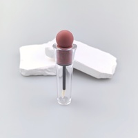 Tube de brillant à lèvres rond avec capuchon décoratif en caoutchouc, style délicat, disponible en marque privée