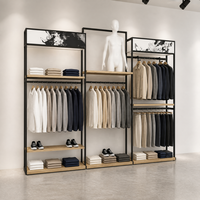 Présentoir mural multi-emplacements en métal noir pour vêtements, avec plateforme pour mannequin et étagère en bois, usage commercial