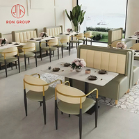 Ensemble de mobilier de restaurant commercial, cadre beige, canapé en cuir vert, banquette avec table carrée en marbre et pieds en métal pour café