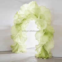 Installation artistique géante de fleurs en organza vert pour vitrine de centre commercial, idéale pour la décoration d'entrée de mariage