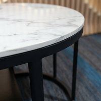 Table basse ovale moderne en marbre blanc avec rangement à double niveau et structure en métal noir pour salon d'entreprise