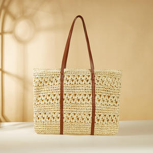 Descubre la esencia de las vacaciones con este precioso bolso de hilo natural diseñado con un cuerpo de malla abierta y asas de cuero marrón. - Product Image 1