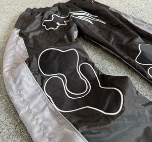 กางเกงแทร็คไนลอนลายกราฟิกทันสมัยสำหรับผู้ชาย เอวยางยืด ทรงหลวม น้ำหนักเบา กันลม แต่งแถบสีตัดกัน จำหน่ายส่ง - Product Image 4