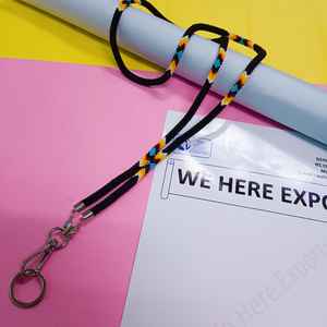 Chaîne de corps perlée faite à la main et colorée, portée par une femme en chemise blanche et avec une carte d'identité, mettant en valeur l'artisanat vibrant des artisans. - Product Image 1