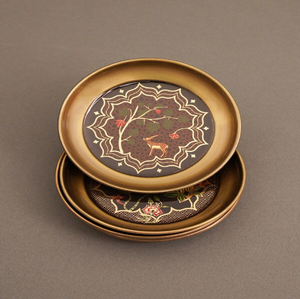 Round antique brass coaster featuring a traditional <b>painted</b> artwork insert with floral motifs, available at wholesale prices. - Product Image 1