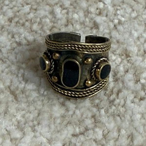Bague tribale afghane ornée d'une incrustation circulaire en lapis-lazuli bleu, de motifs floraux en argent estampés à la main et d'accentuations de perles délicates - Product Image 1