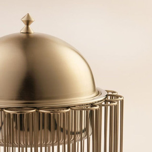 Plat à réchaud élégant finition or, présenté sur un support en fil métallique style cage avec couvercle en dôme, idéal pour les événements gastronomiques et les mariages. - Product Image 3