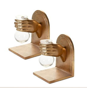 Sujetalibros decorativos dorados en forma de mano que sostienen jarrones de vidrio transparente para una estética botánica; arte disponible a precios de mayorista. - Product Image 1
