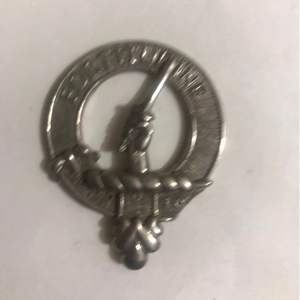 Ceci est un badge de blason du clan Grant en étain. Il porte le motto du clan, « Stand Fast », et le blason d'une montagne enflammée. - Product Image 2