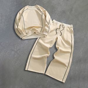 Ensemble décontracté deux pièces pour homme : sweat-shirt beige crème à col rond avec passepoil contrastant et pantalon de survêtement large à cordon de serrage - Product Image 1