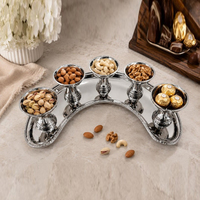 Ensemble de bols en argent au design élégant. 5 bols métalliques surélevés sur un plateau en forme de croissant pour un service de luxe, des collations et des condiments