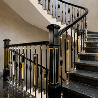 Rampe d'escalier de luxe noire et or avec un design élégant et courbé et des marches en marbre poli pour une décoration intérieure moderne