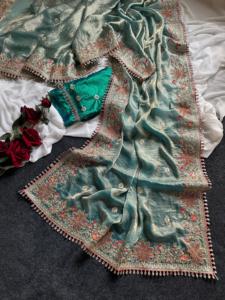 El sari viene en una hermosa tela brillante con un borde floral y bordados detallados, y pequeños borlas colgantes que añaden un toque real. - Product Image 3