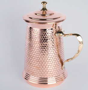 Polished <b>copper</b> carafe with a textured body design, matching lid, and ornate golden <b>handle</b>, available at wholesale price. - Product Image 1