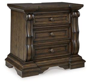 Esta es una mesita de noche Maylee de Ashley Furniture con un acabado en madera marrón oscuro y apliques ornamentales para uso en el dormitorio. - Product Image 1