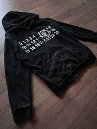 Comprend une grille numérotée blanche audacieuse (de 0 à 23) sur la poitrine avec un emblème circulaire central en forme de crâne et de boulon, inspiré des motifs graphiques. - Product Image 2