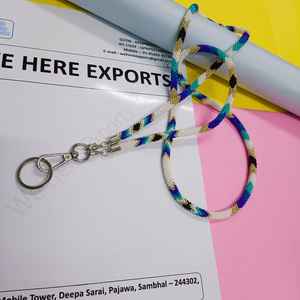 สร้อยประดับร่างกายทำมือหลากสีสันที่สวมใส่โดยผู้หญิงที่สวมเสื้อสีขาวและมีบัตรประจำตัวที่มองเห็นได้ แสดงถึงงานฝีมือของช่างฝีมืออย่างภาคภูมิใจ - Product Image 2