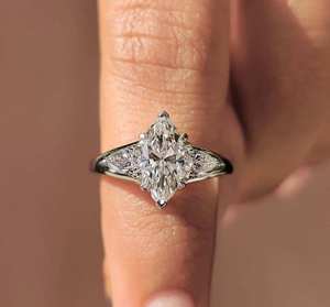 Bague de luxe en diamant taille marquise à trois pierres avec diamants latéraux en forme de poire, bijou raffiné pour fiançailles, mariage ou anniversaire, un chef-d'œuvre de joaillerie fine. - Product Image 1
