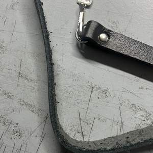 Ce produit est un accessoire vestimentaire des Highlands, décrit comme une chaîne sporran à motif celtique en nickel avec sangles en cuir noir. - Product Image 2