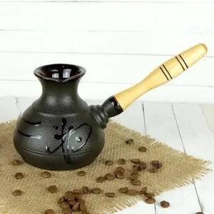 Carafe à café turc au design vintage, fabriquée en métal orné avec une longue poignée en bois pour servir un café riche et moussant - Product Image 1