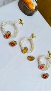 Elegant handcrafted pearl <b>bracelet</b> <b>set</b> featuring traditional paisley motif charms adorned with kundan style stones - Product Image 2